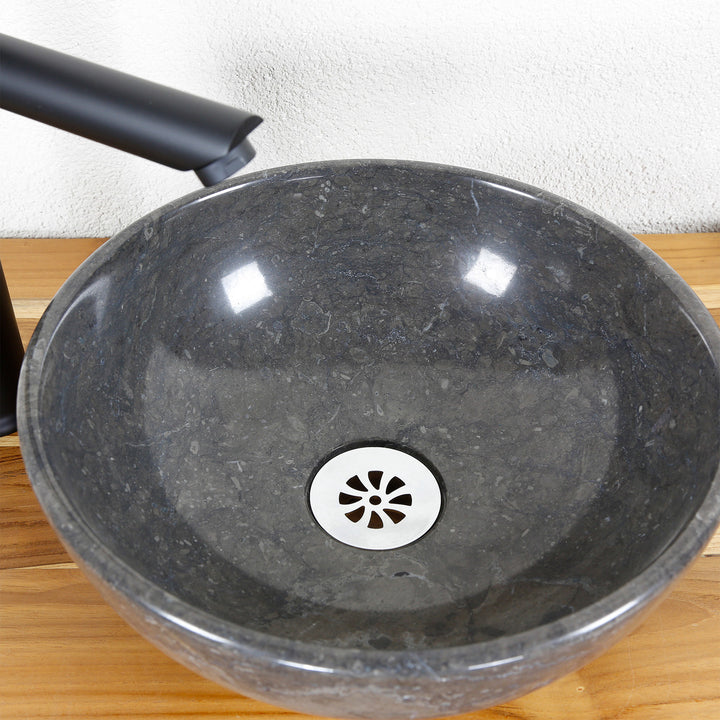 Rundes Aufsatzwaschbecken aus Naturstein in Detailansicht mit polierter Innenfläche, Edelstahl-Ablauf und Armatur