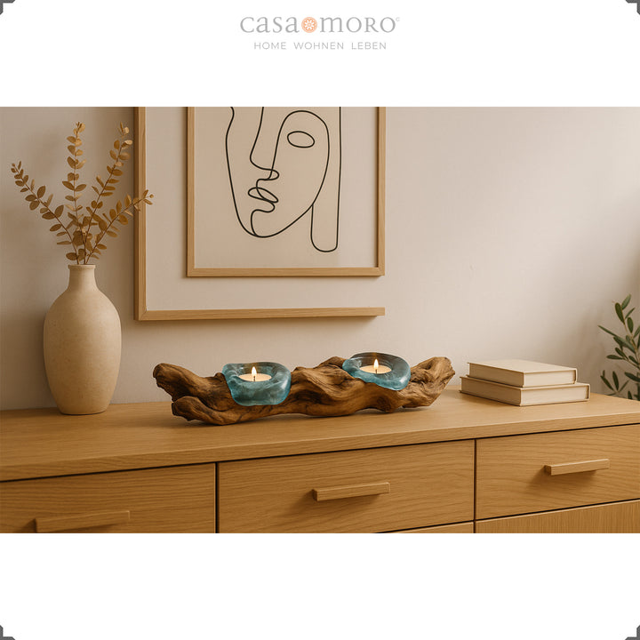 Länglicher Teelichthalter aus Glas und Wurzelholz auf einem Sideboard, sein sanftes Licht ergänzt die natürliche, moderne Wohnraumgestaltung.