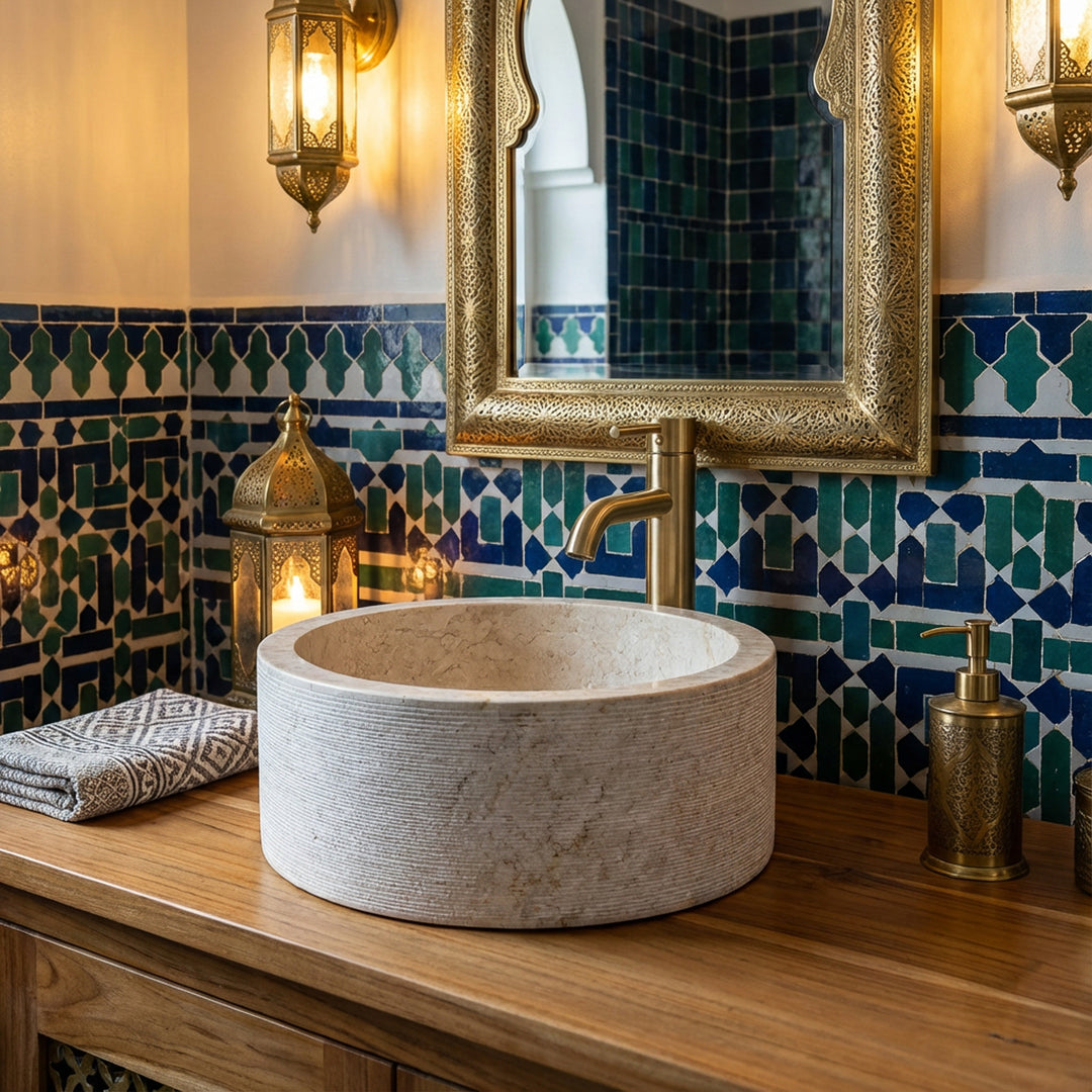 Rundes Marmor-Waschbecken auf Holzkonsole, stimmungsvoll inszeniert im orientalischen Bad mit Mosaikfliesen und Messingdetails.