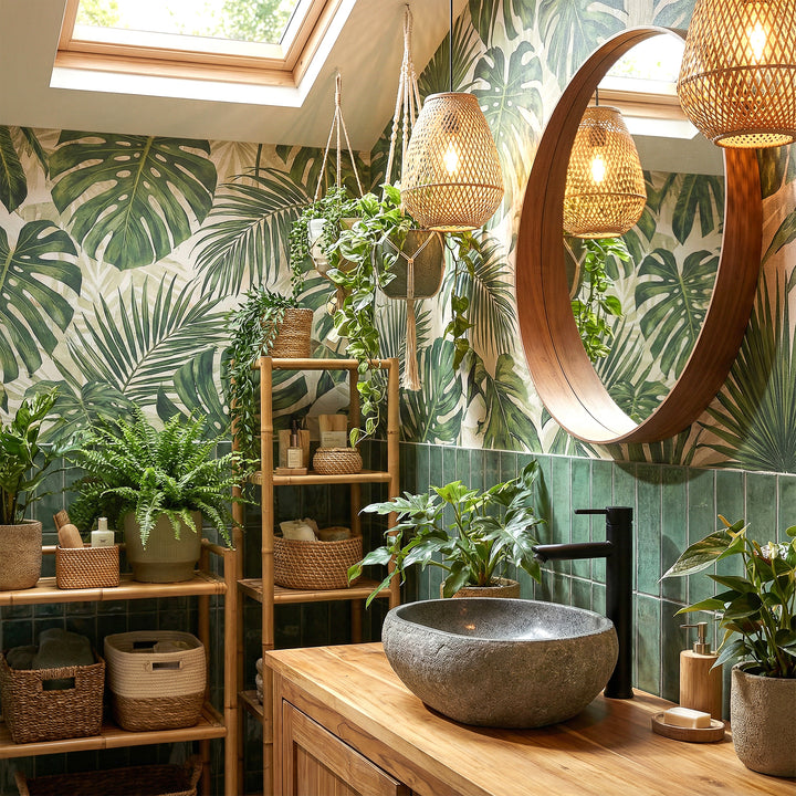 Flussstein Aufsatzbecken im grünen Spa-Bad auf Holzwaschtisch, kombiniert mit schwarzer Armatur und Pflanzenambiente