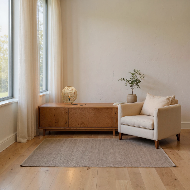 Visualisierung der Rattan-Tischlampe LP029 mit Ringfuß auf einem Holzsideboard neben einem beigen Sessel
