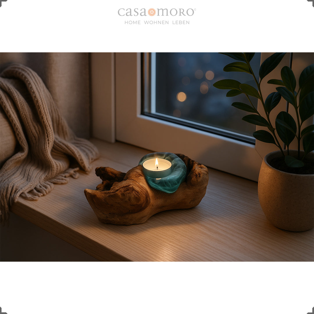 Teelichthalter aus Glas und Wurzelholz auf einer Fensterbank, sein sanftes Licht sorgt am Abend für eine ruhige, wohltuende Stimmung.
