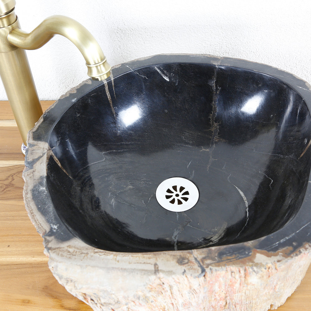 Steinwaschbecken aus versteinertem Holz mit dunkler, polierter Innenfläche, Draufsicht mit Ablauf und Messingarmatur auf Holzplatte.